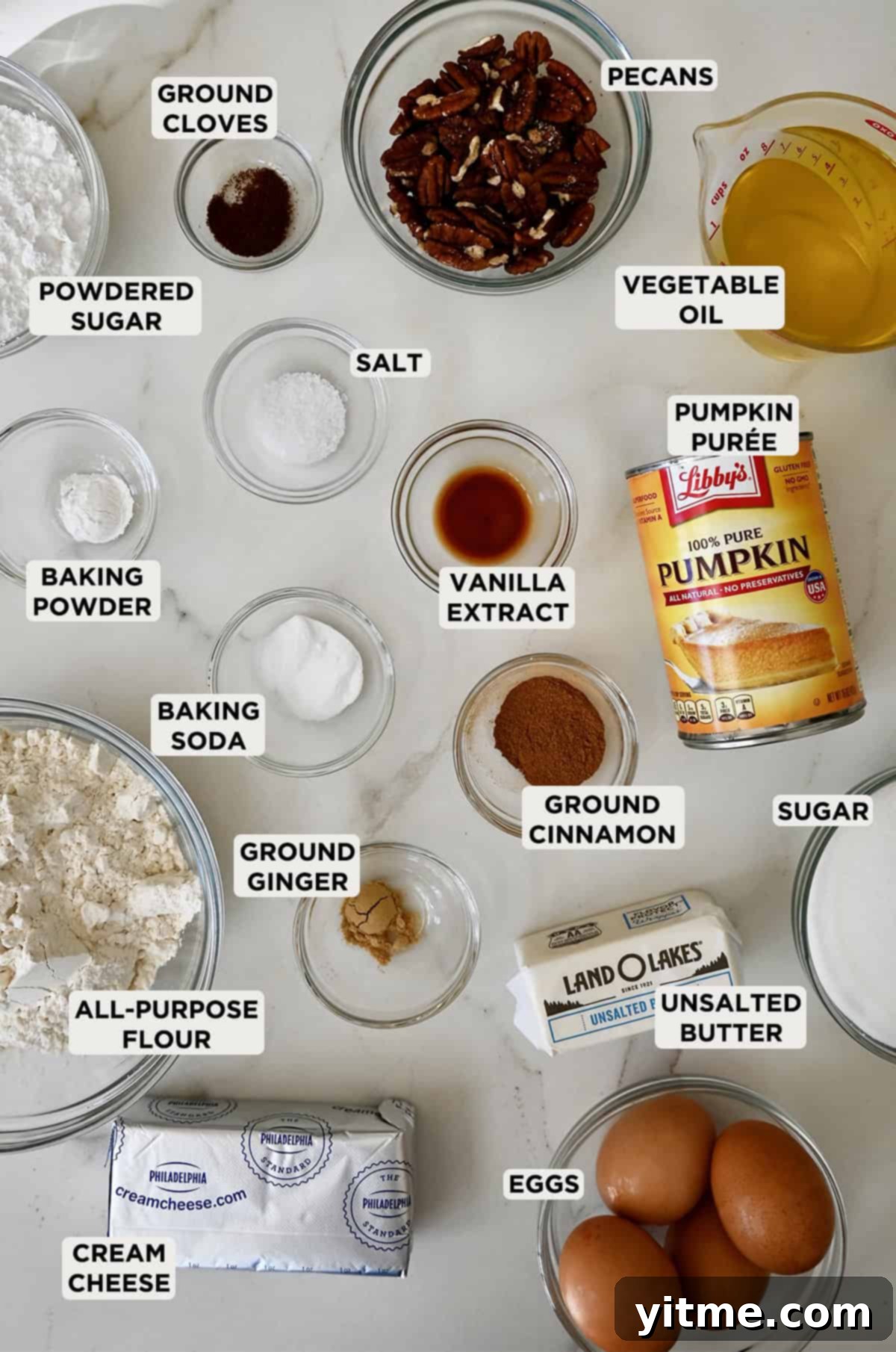 Ingredients for pumpkin bars with cream cheese frosting in glass bowls.