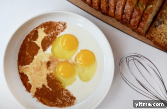 Banana Bread Bliss: A Decadent French Toast Twist 3 Banana Bread French Toast batter in white bowl with whisk