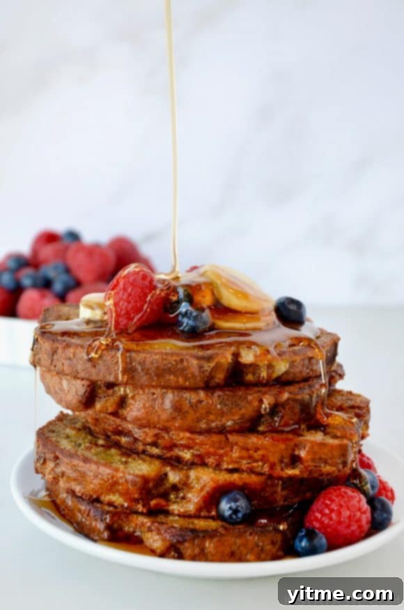 Banana Bread Bliss: A Decadent French Toast Twist 7 Stack of Banana Bread French Toast with maple syrup drizzle and fresh fruit