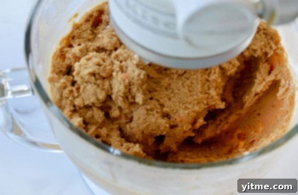 Glass stand mixer bowl containing cookie dough