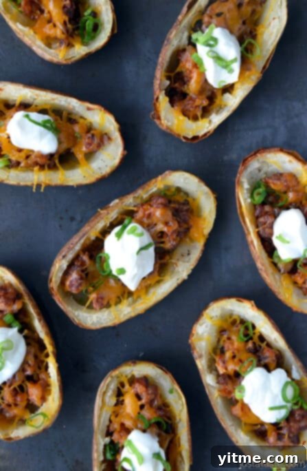 Baked potato skins with chorizo topped with dollops of sour cream and sliced scallions.