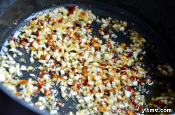 Zesty Orange Baked Chicken Wings 4 Small saucepan with orange chicken sauce simmering.