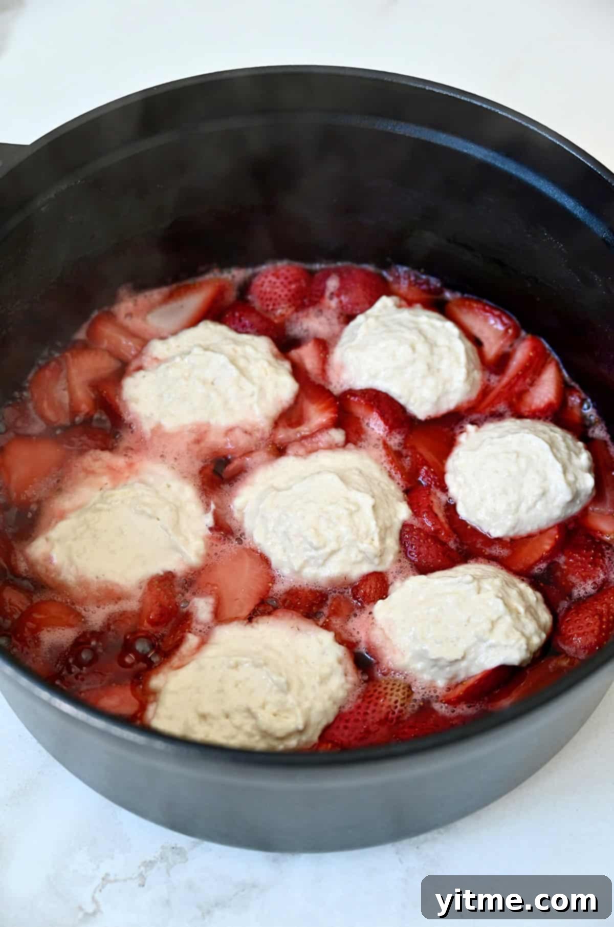 Strawberry sauce topped with uncooked dumplings