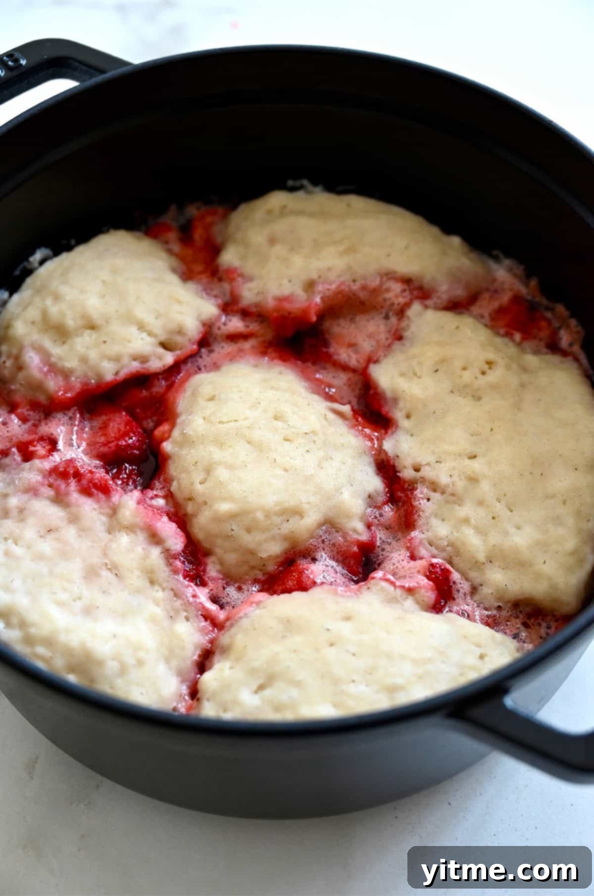 Stovetop strawberries and dumplings in a saucepan