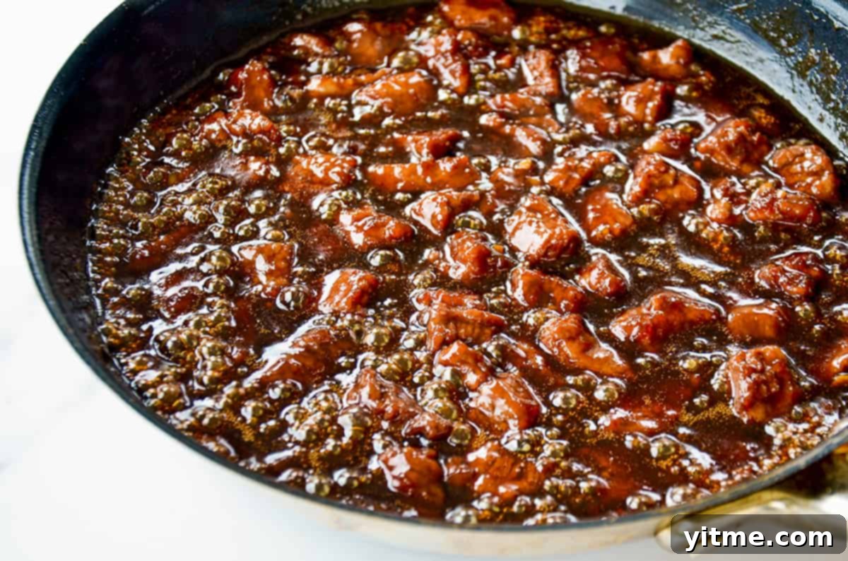Mongolian stir fry sauce and flank steak in a large skillet.