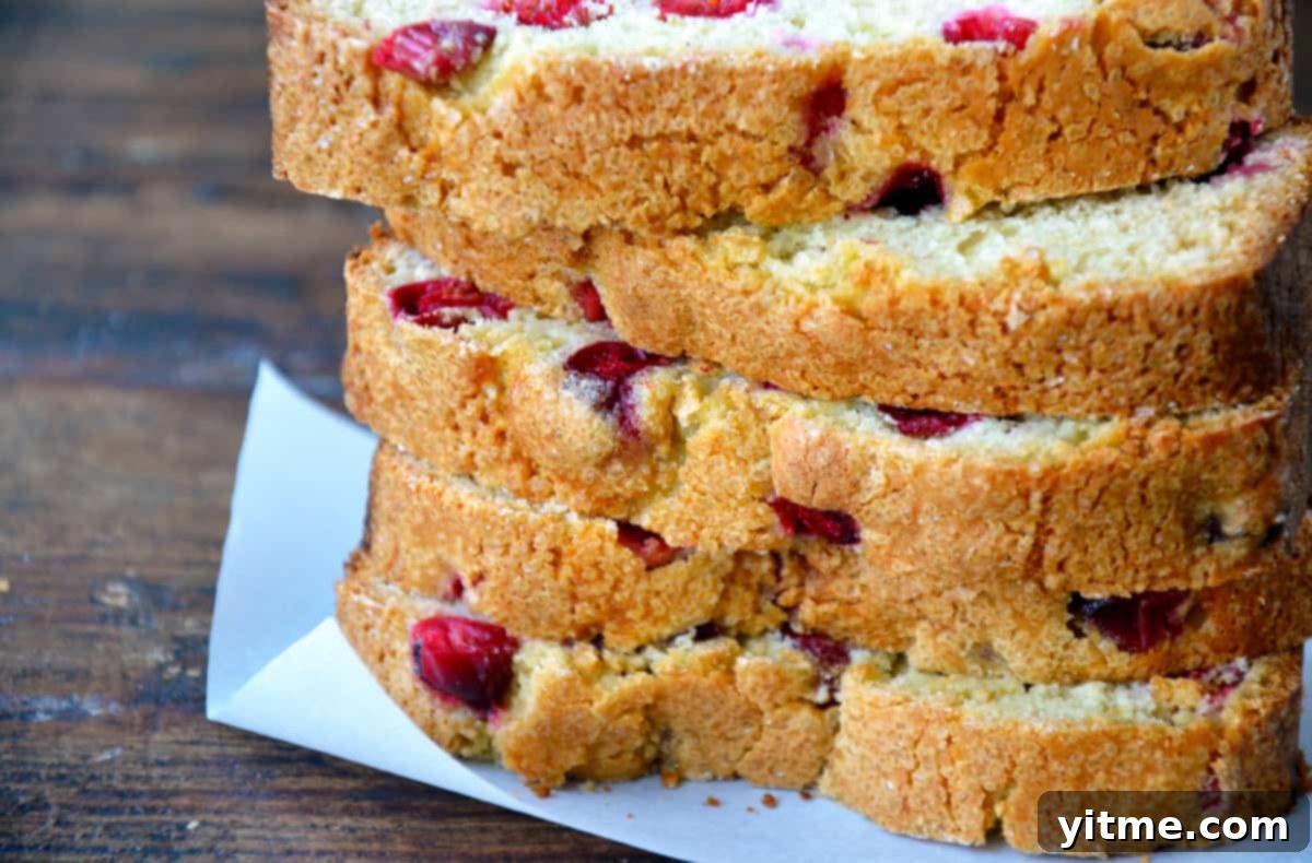 Six slices of cranberry orange bread neatly stacked on a white background.