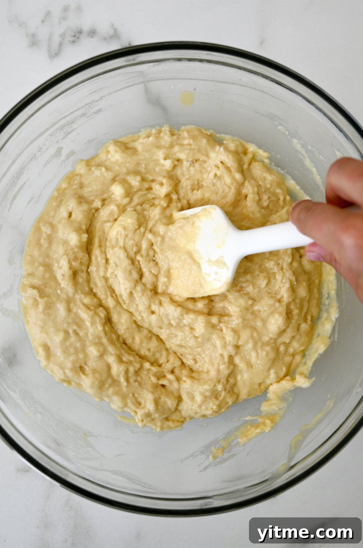 A bowl filled with a well-mixed cranberry orange quick bread batter.