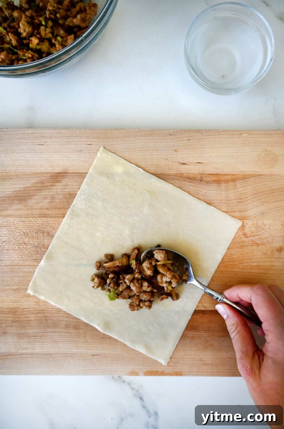 Adding the chicken mixture to the spring roll wrapper.