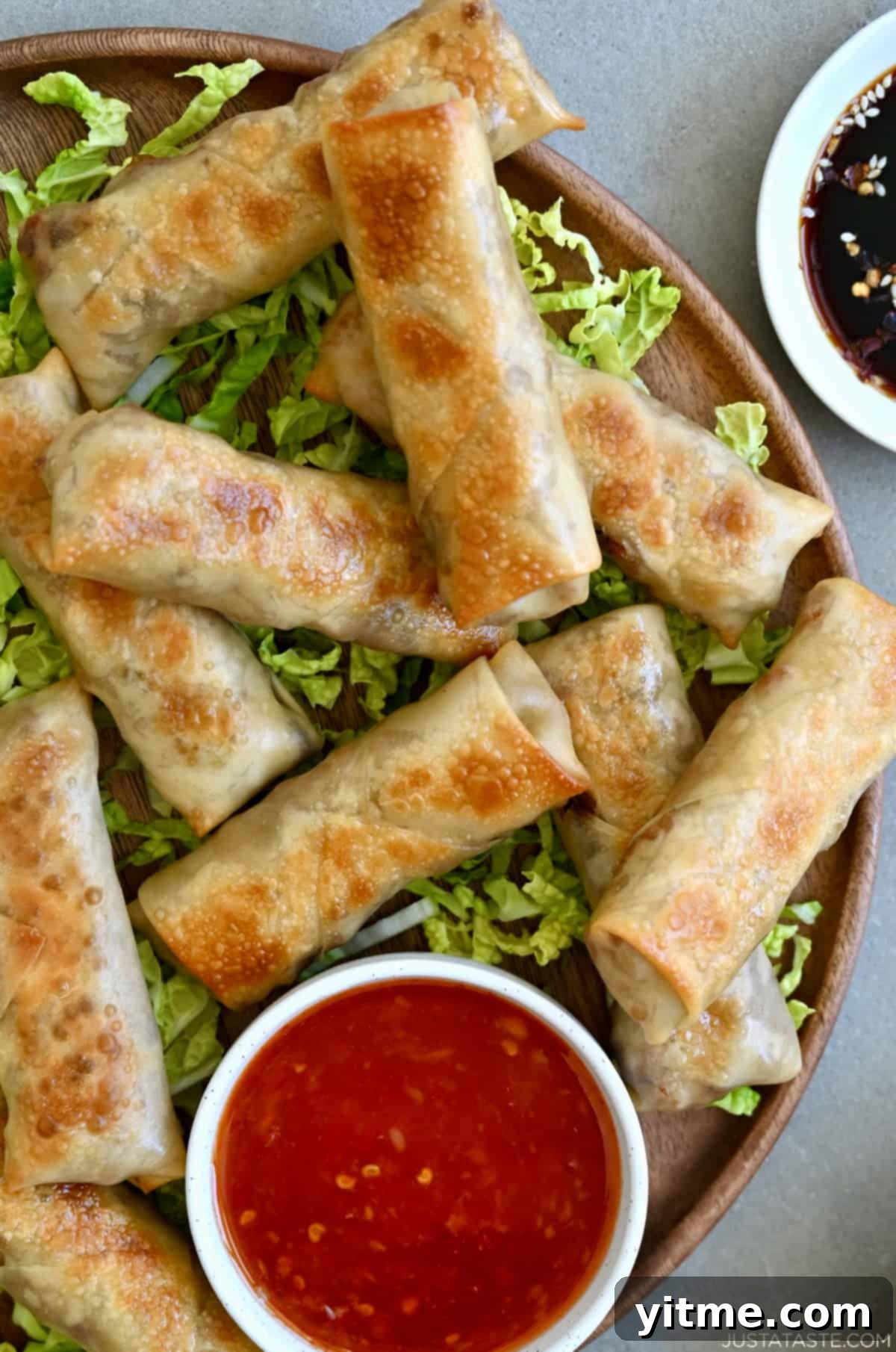 Close up of baked chicken spring rolls with sweet chili sauce.