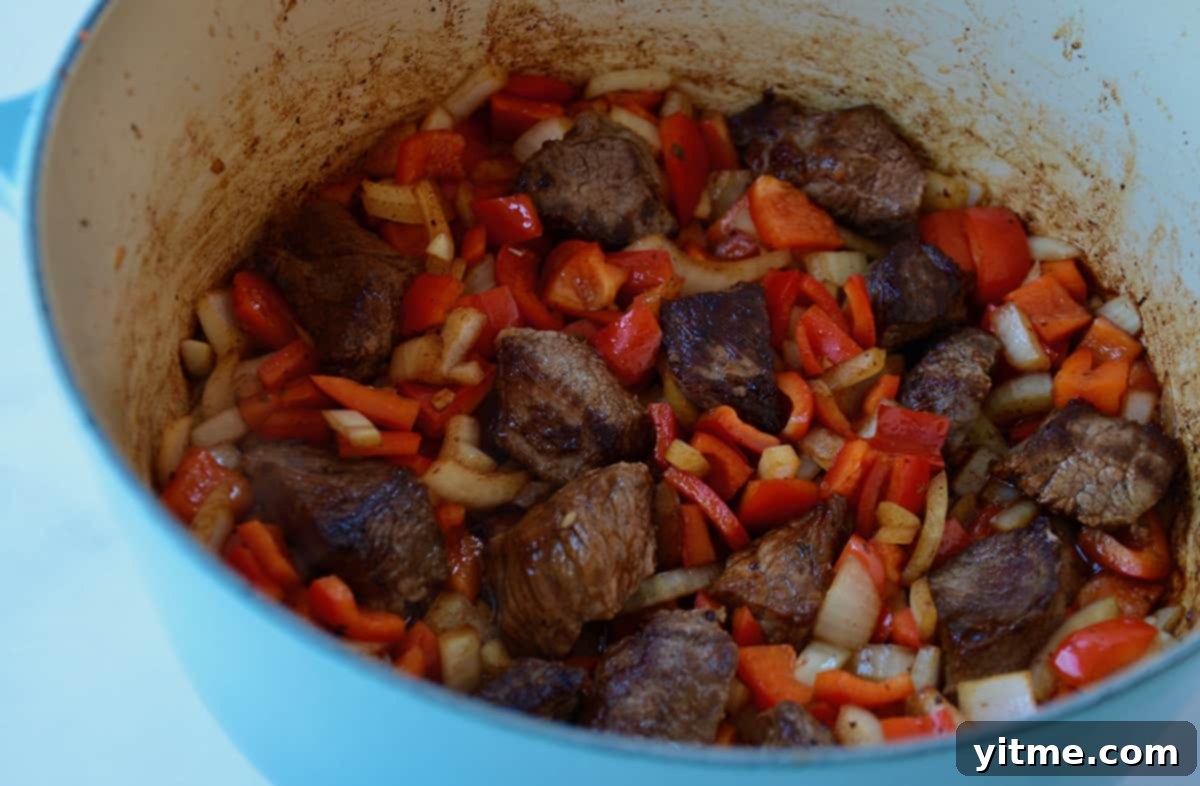 Browned beef and sauteed vegetables in a Dutch oven