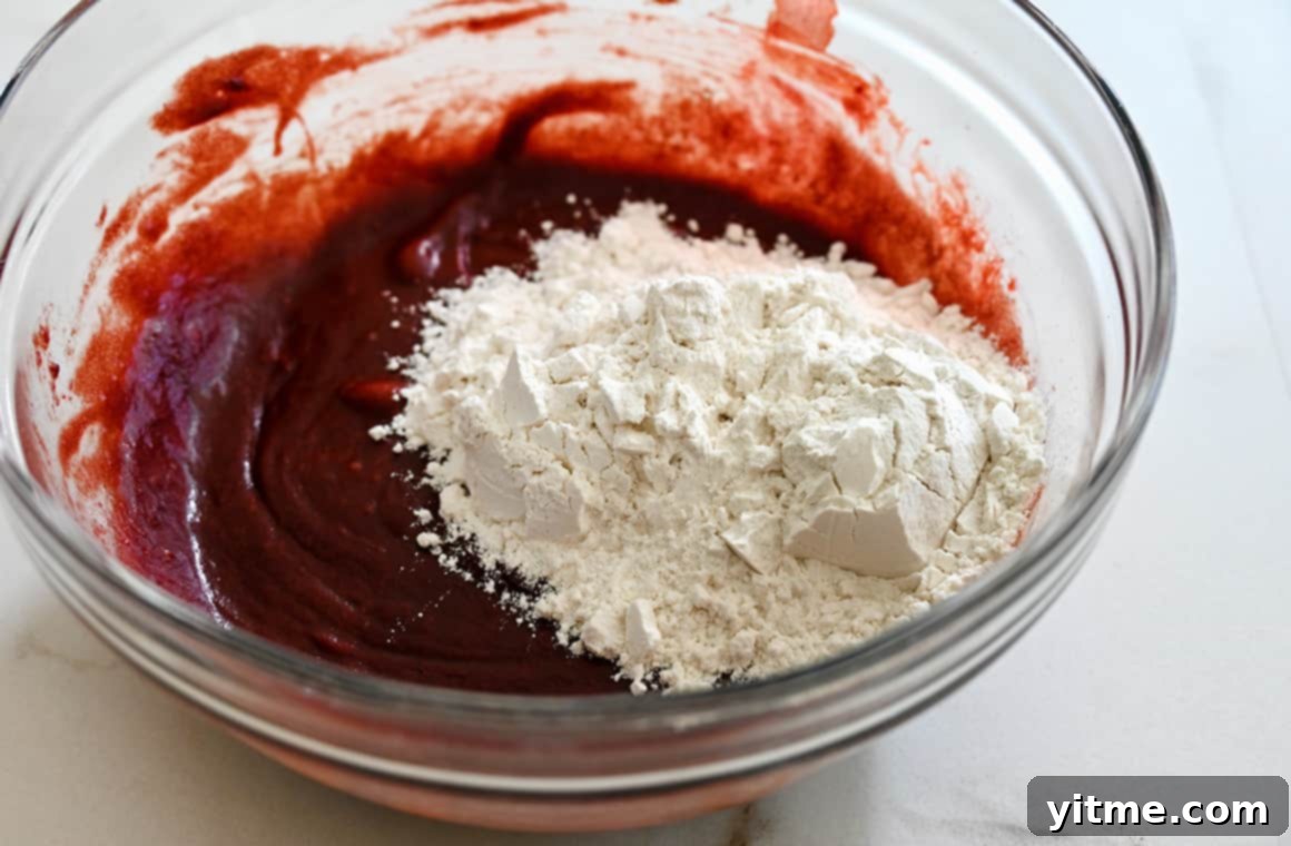 Red velvet brownie batter in a clear bowl