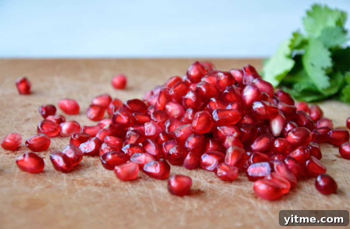 A pile of pomegranate seeds on a cutting board.