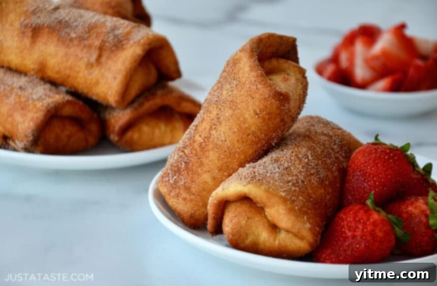 Strawberry Cheesecake Chimichangas on a white plate next to fresh strawberries