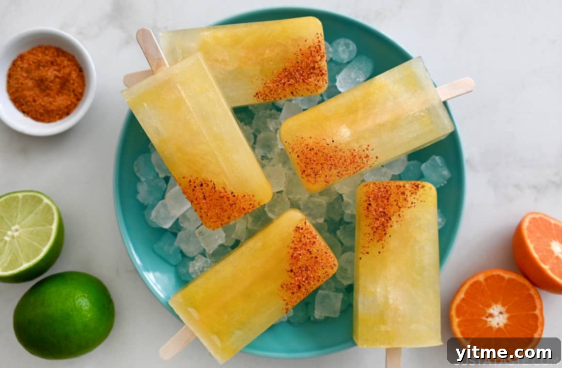 Skinny Margarita Popsicles with tajin seasoning over ice, lime, and orange
