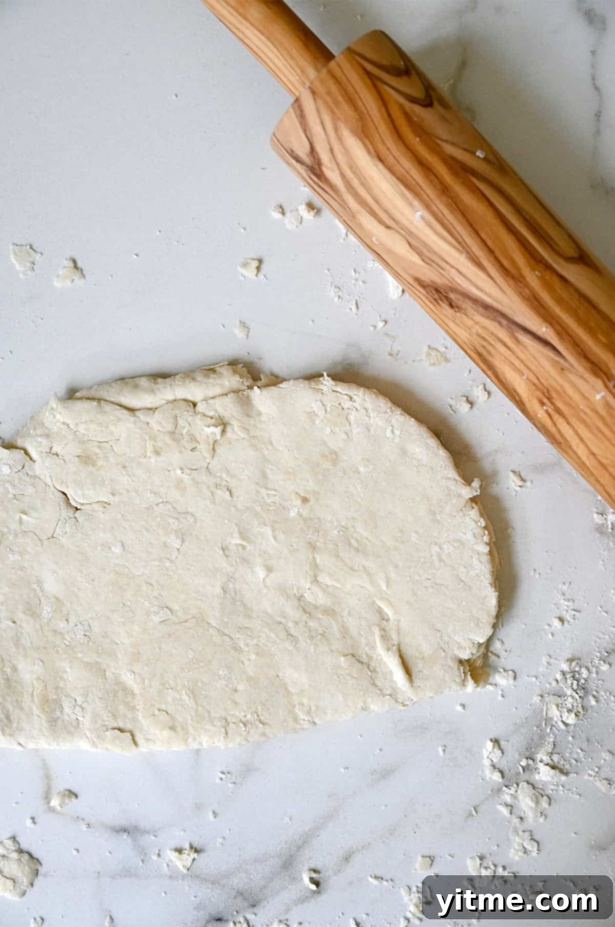 Quick Strawberry Shortcake 6 Shortcake dough rolled out on a lightly floured surface next to a rolling pin.