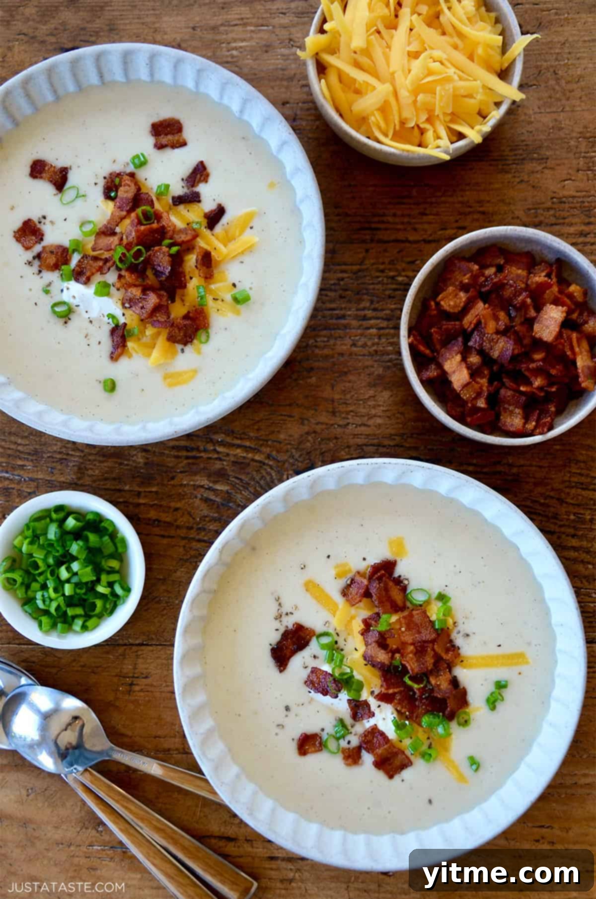 Creamy Potato Soup with Crispy Bacon and Cheddar 2 Bowls of creamy potato soup topped with bacon, cheese, sour cream, and green onions.