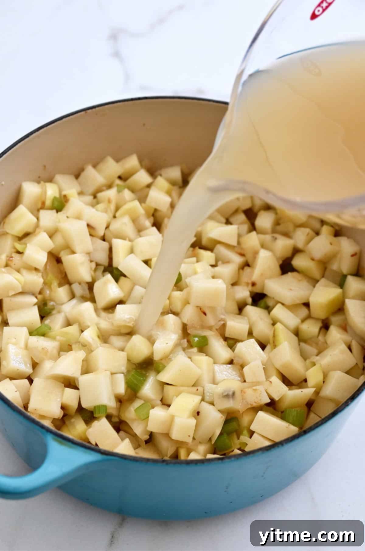 Creamy Potato Soup with Crispy Bacon and Cheddar 6 Adding potatoes and chicken stock to the pot.