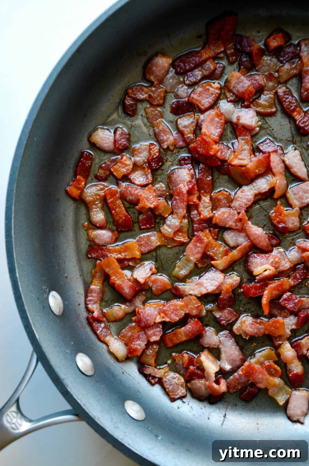 Bacon cooking in a skillet.