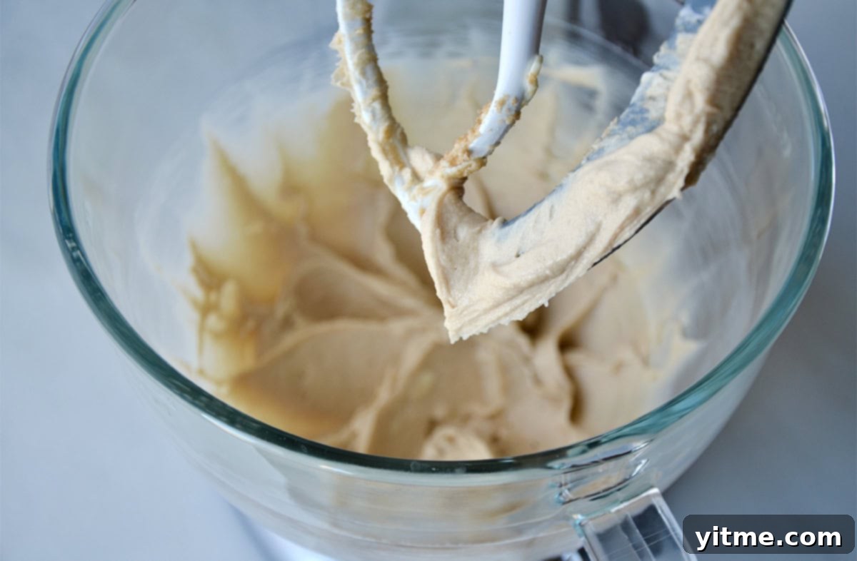 Sticky bun batter being creamed in a stand mixer.