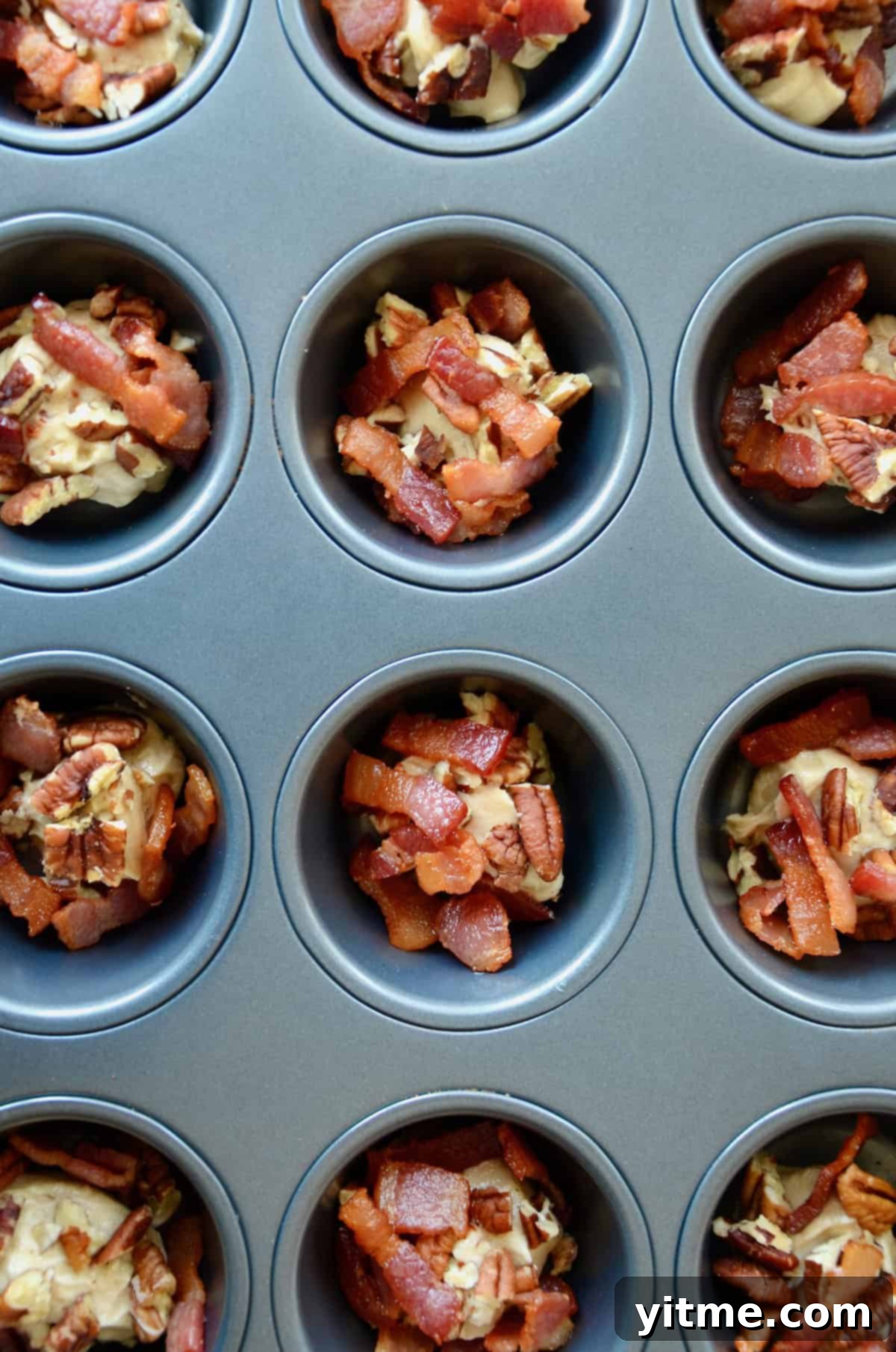 Butter, bacon, and pecans in a muffin tin.