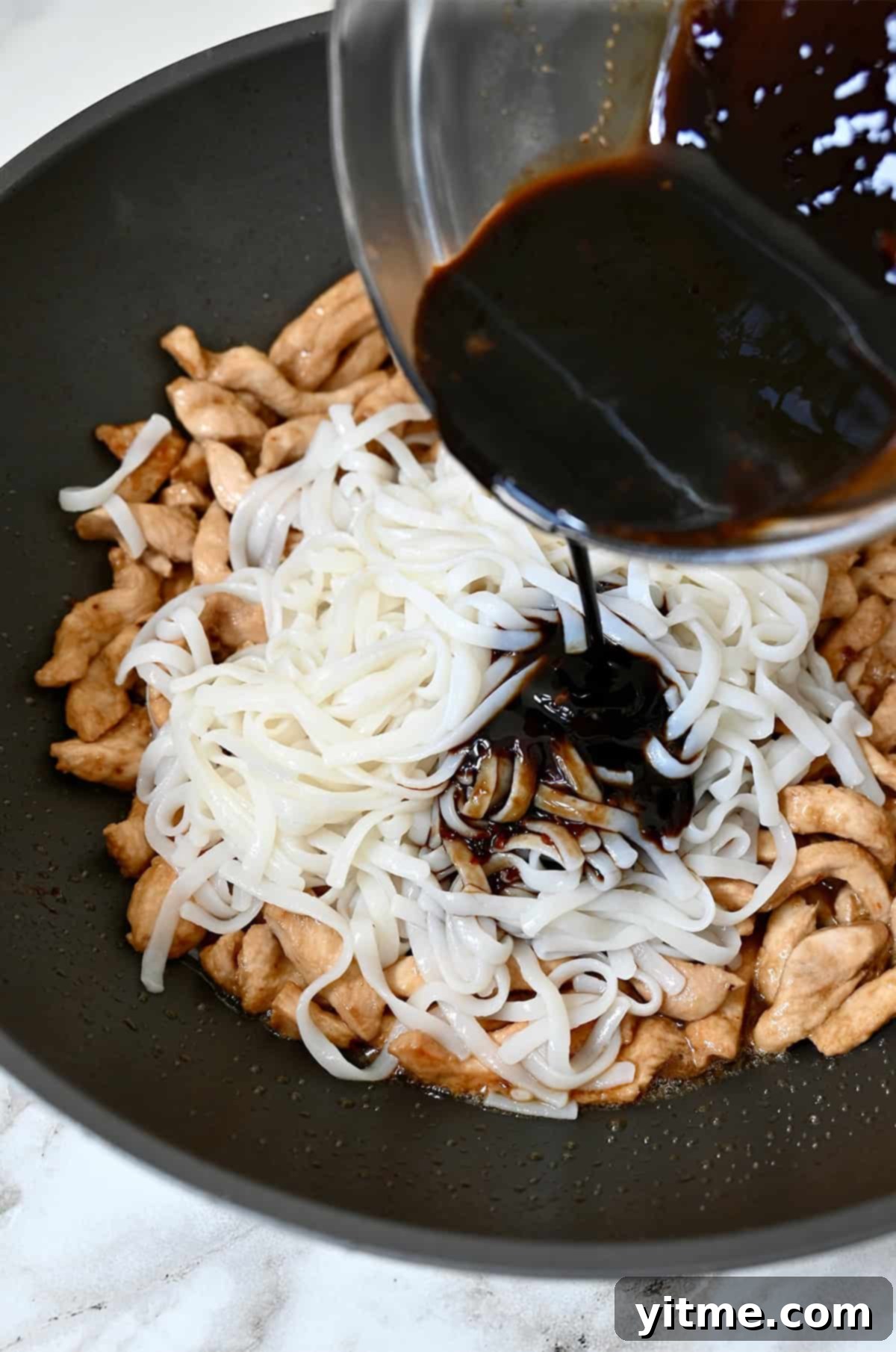 Adding Sauce to Noodles and Chicken