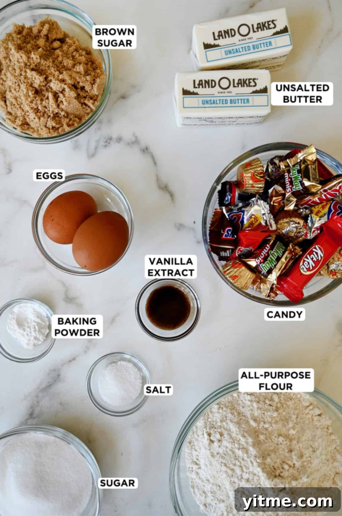 Candy bar blondie ingredients in glass bowls.