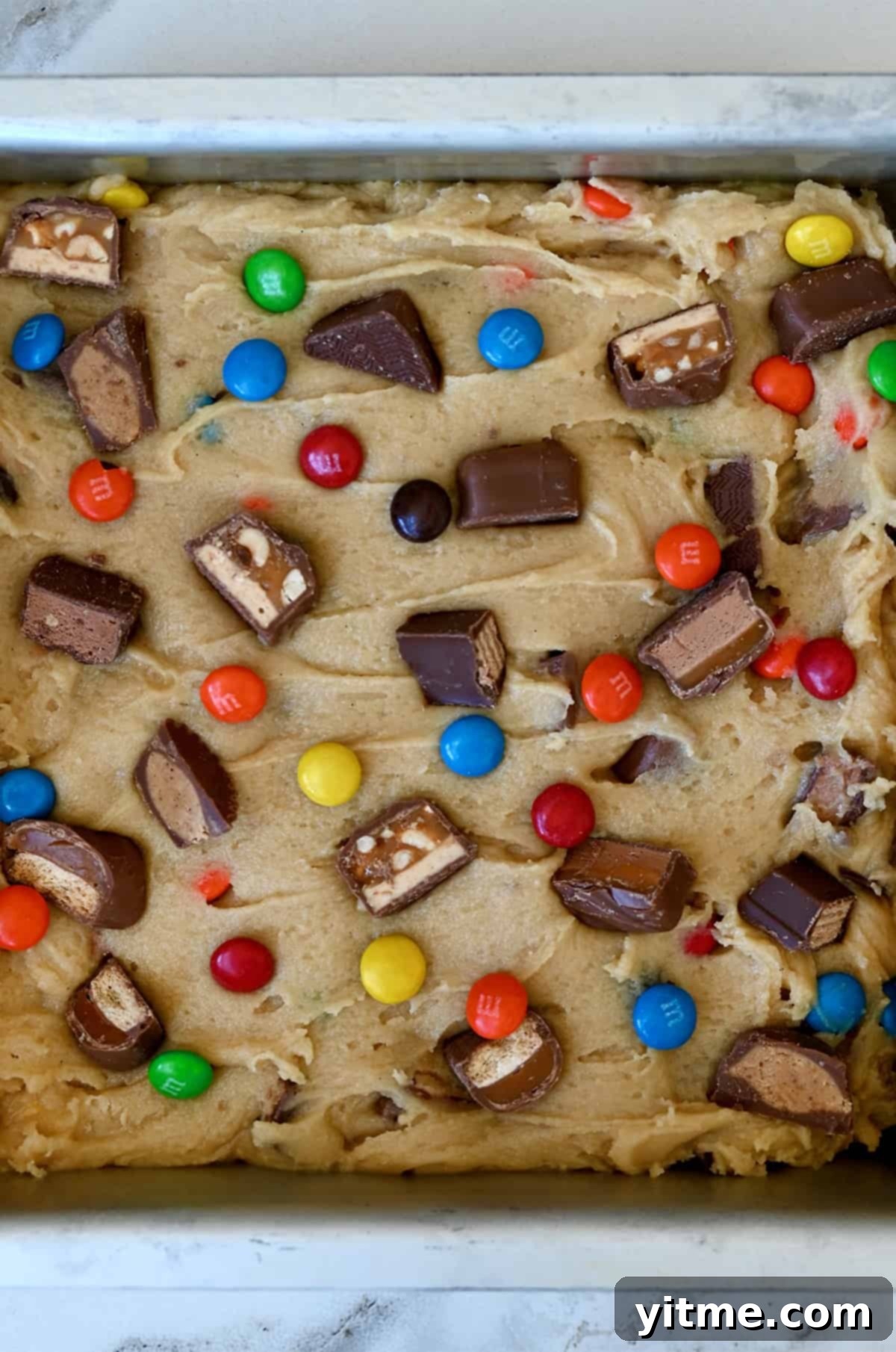 Unbaked candy bar blondies in a baking dish.