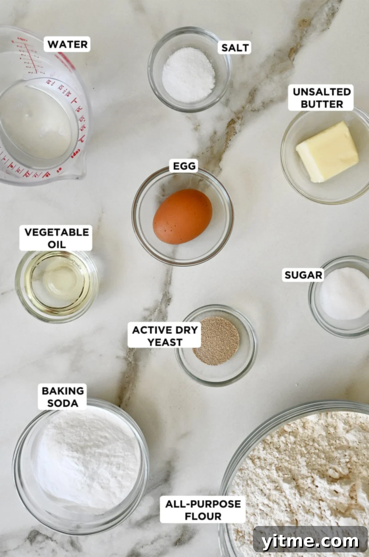 Ingredients to make soft pretzels including water, salt, butter, sugar, active dry yeast, all-purpose flour, baking soda, and vegetable oil.