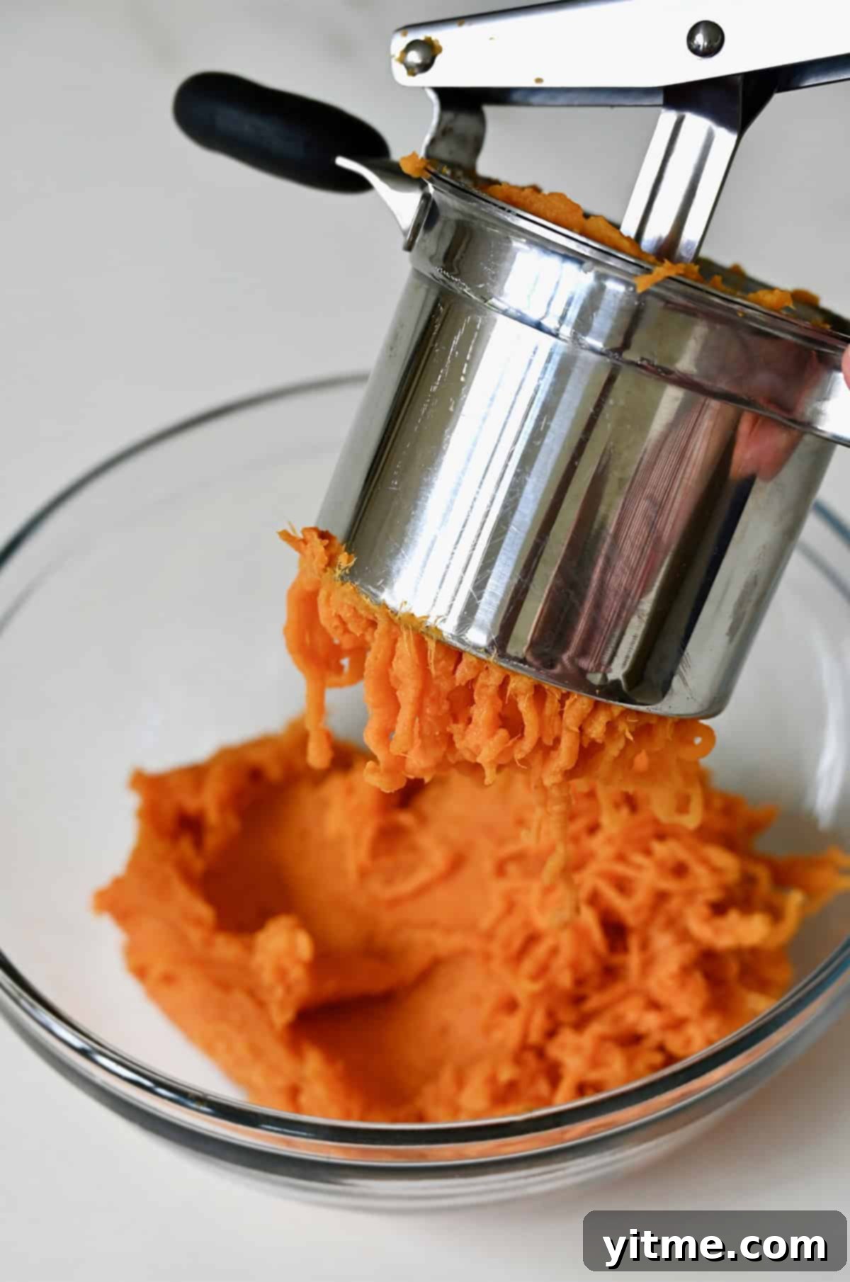 Sweet Potato Gnocchi in Balsamic Brown Butter Sauce 5 Passing the flesh of a sweet potato through a potato ricer into a glass bowl.