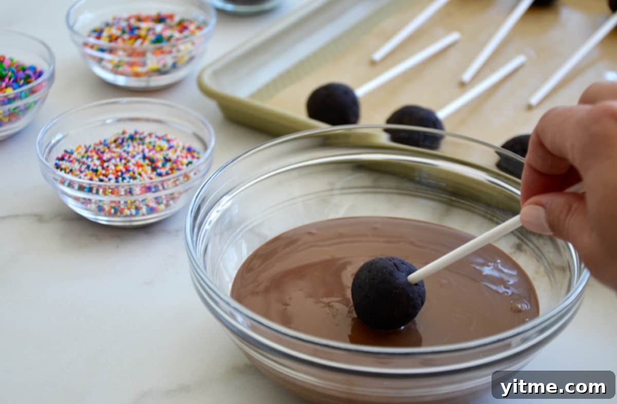 Chocolate Cookie Pops: The Easiest Dessert Ever 6 Dipping a chocolate cookie pop in melted chocolate