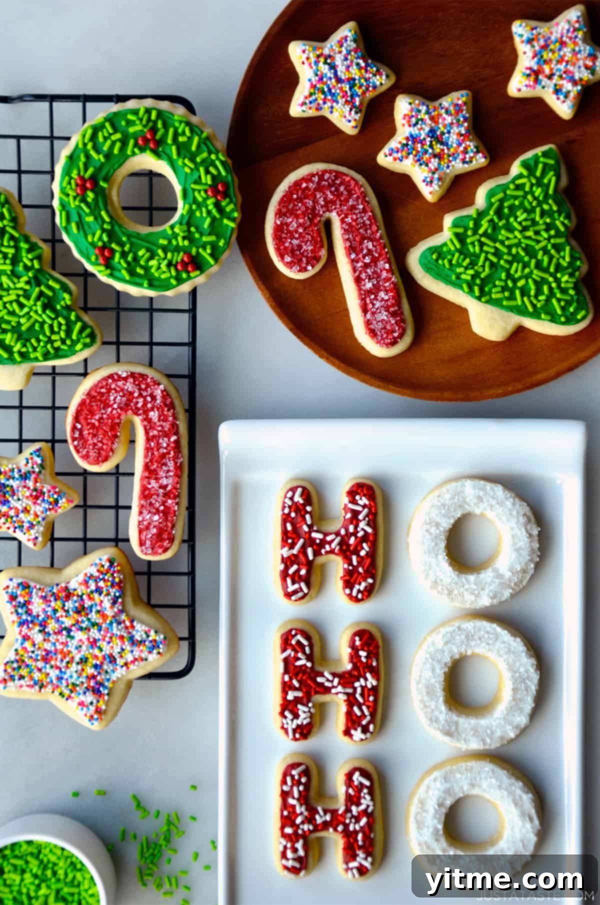 Delicious sugar cookies with frosting and sprinkles on a wire cooling rack, on a plate, and on a white serving platter.