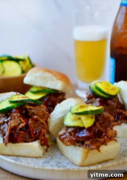 Balsamic Honey Pulled Pork: A Slow Cooker Delight 11 White buns piled high with Instant Pot Barbecue Pulled Pork and pickles in front of a bottle and glass of beer