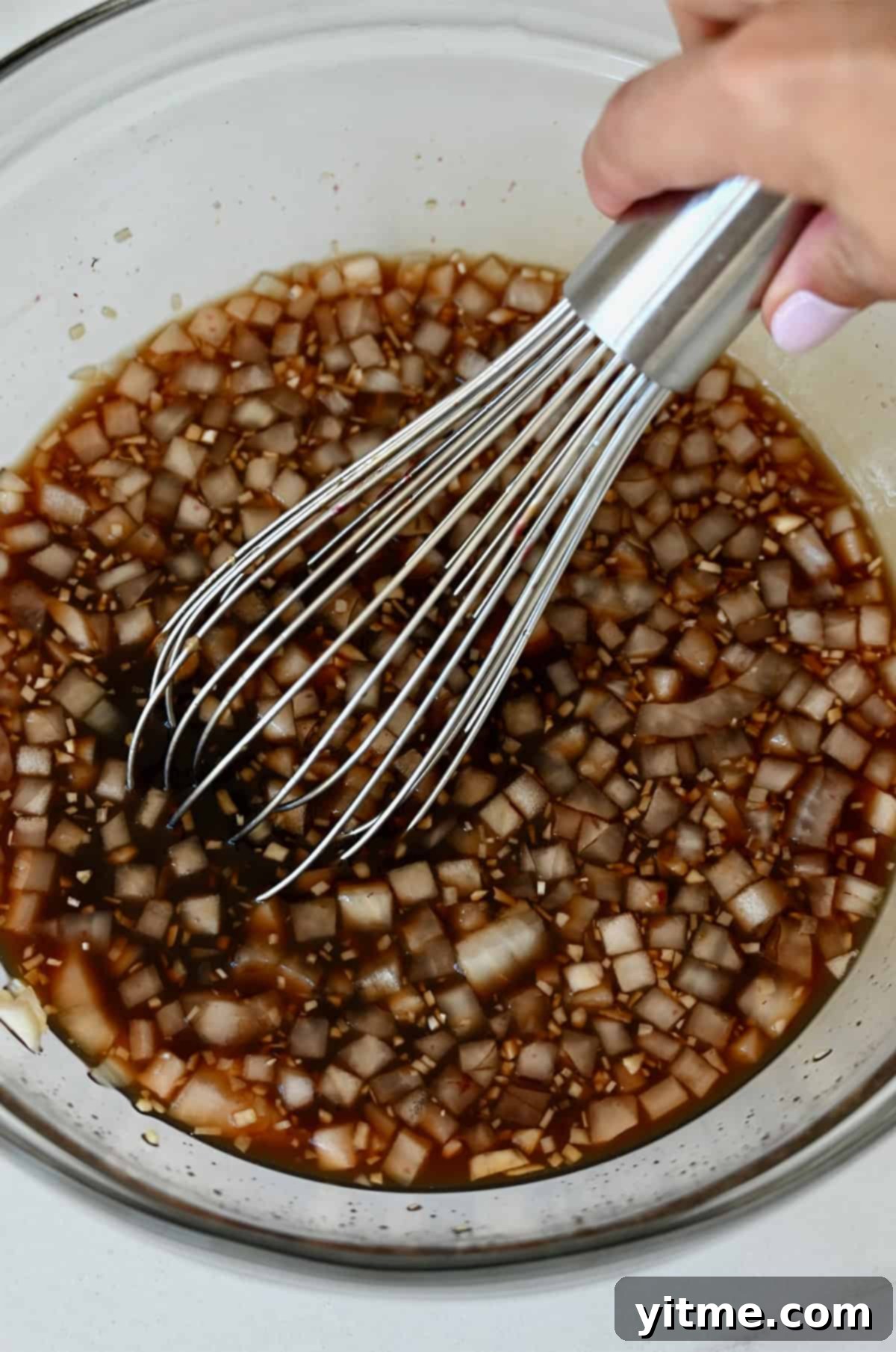 Balsamic Honey Pulled Pork: A Slow Cooker Delight 4 Diced onions being whisked into a balsamic honey sauce in a bowl.