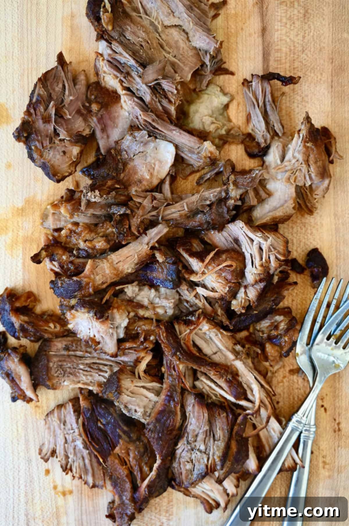 Balsamic Honey Pulled Pork: A Slow Cooker Delight 6 Two forks on a cutting board with shredded pulled pork.