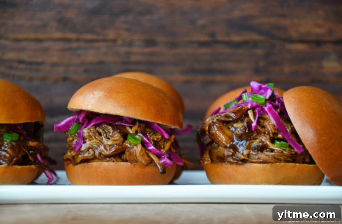 Balsamic Honey Pulled Pork: A Slow Cooker Delight 9 Pulled pork sandwiches with cole slaw on a white plate.