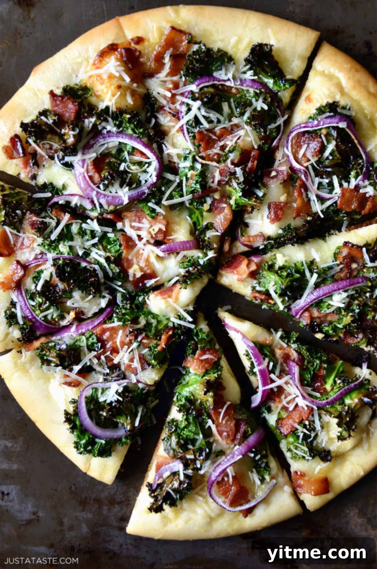 Garlic-Kissed Kale & Bacon Pie 2 Sliced kale and bacon pizza topped with grated parmesan cheese and red onion.