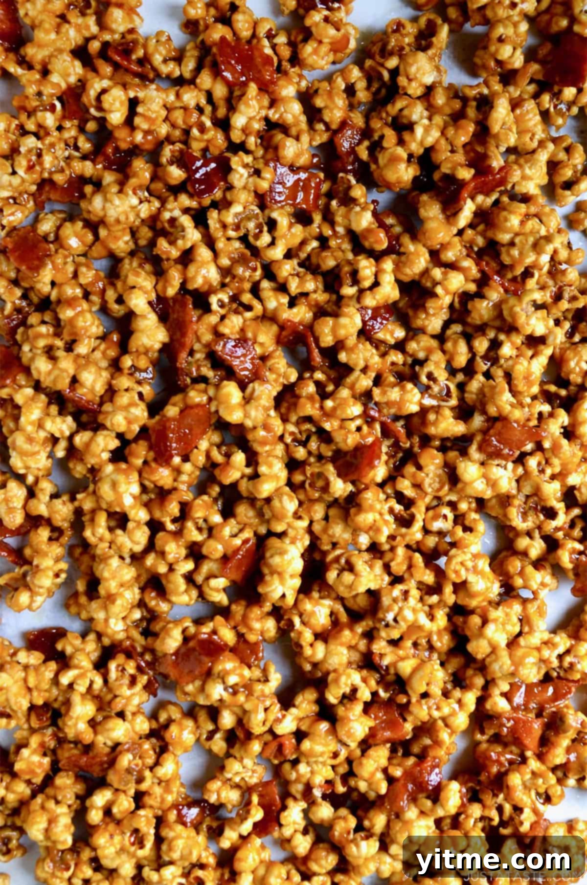 Caramel popcorn with bacon on a parchment-lined baking sheet