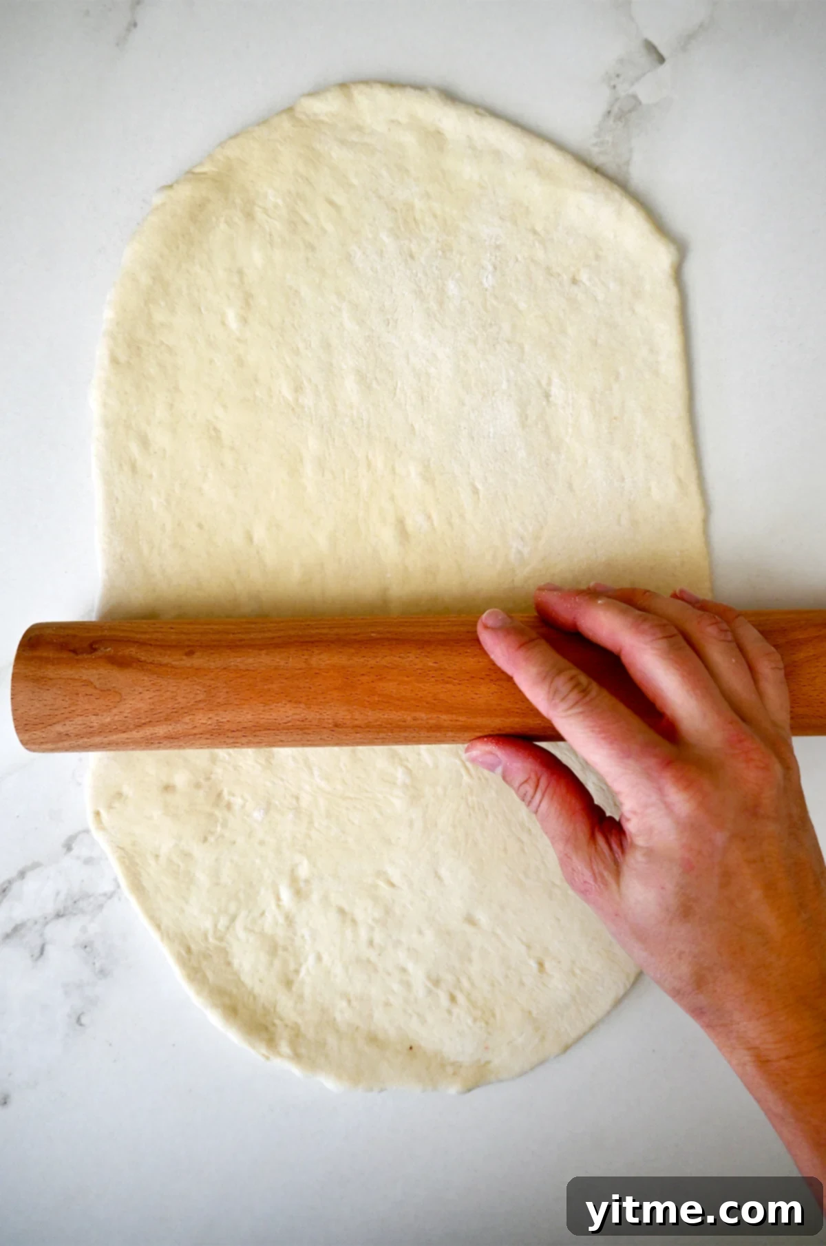 Rolling out pizza dough into a 12-inch circle.