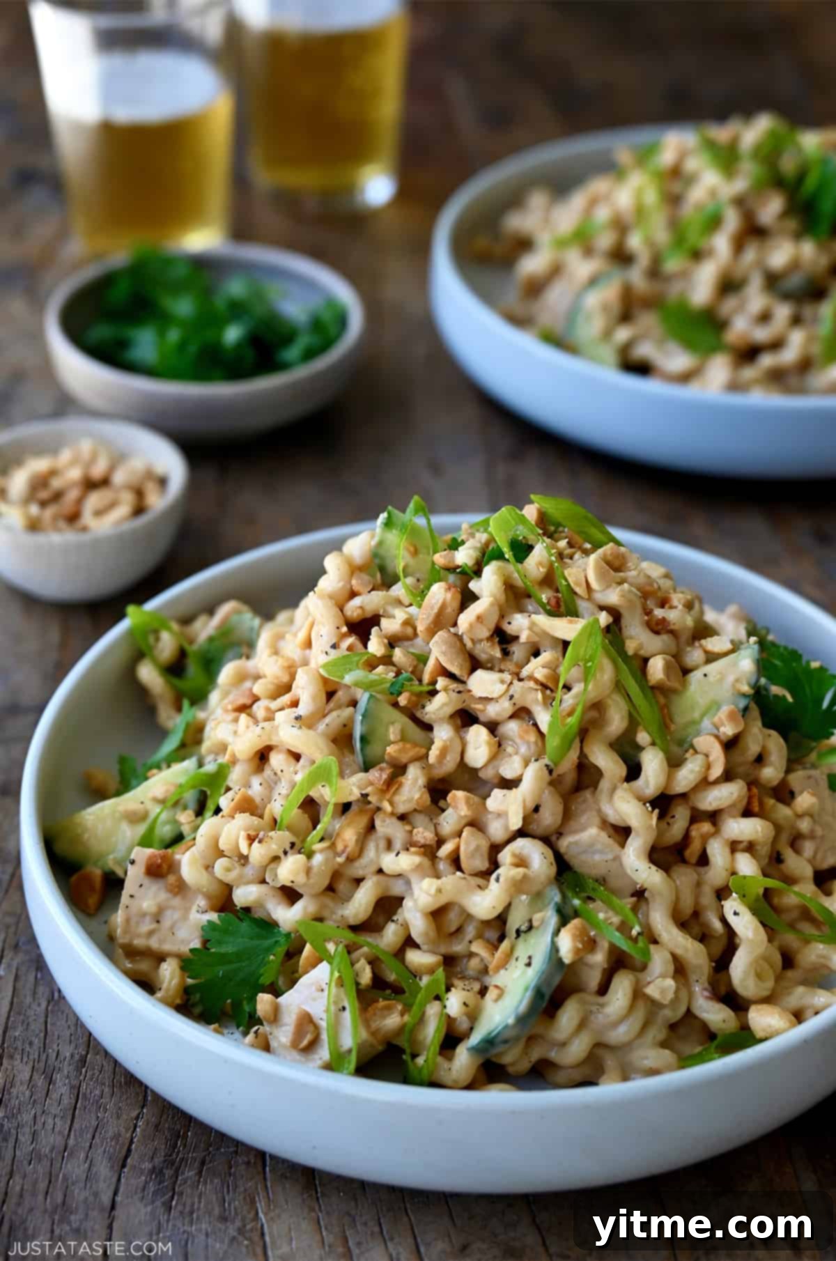 Thai Chicken Pasta Salad garnished with scallions and peanuts