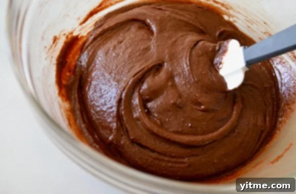 Brownie batter in clear bowl with spatula
