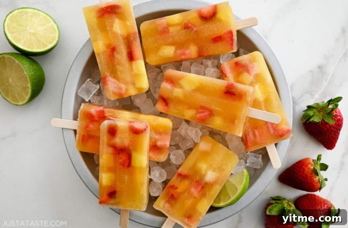 A bowl filled with crushed ice, showcasing several homemade Peach Sangria Popsicles, perfect for a summer refreshment.