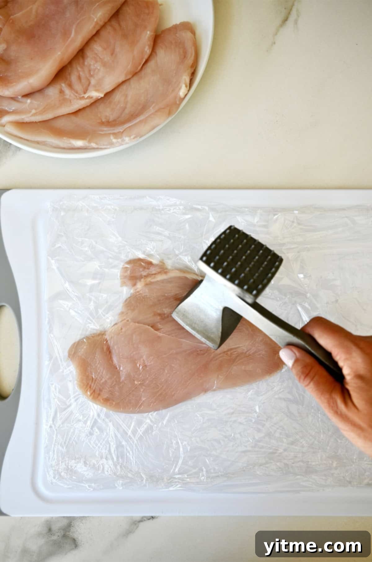 Pounding chicken breasts thin for Chicken Milanese