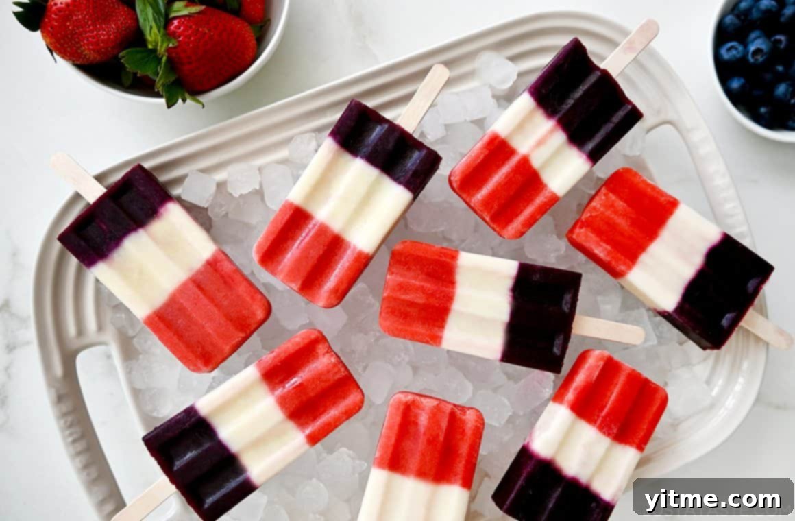 A white platter topped with crushed ice and red, white and blue popsicles, ready for a party
