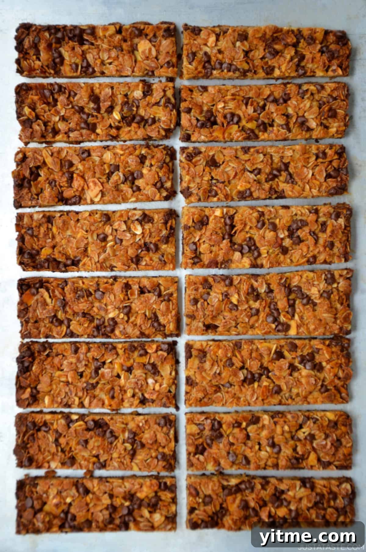 Close-up of soft and chewy homemade chocolate chip granola bars arranged on a wooden surface.