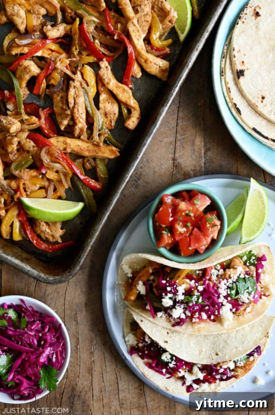 A top-down view of Sheet Pan Chicken Fajitas next to a plate with a stack of corn tortillas