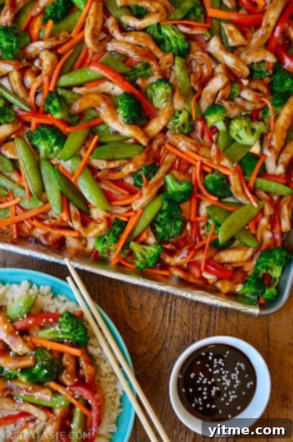 A sheet pan with chicken teriyaki and vegetable next to a plate