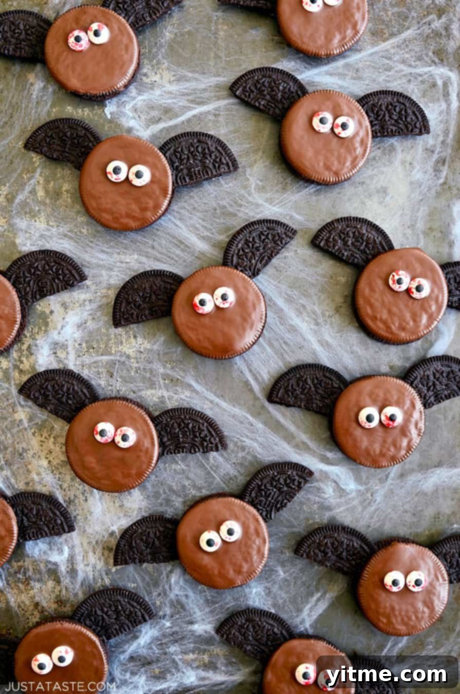 A top-down view of No-Bake Oreo Bat Cookies with bloodshot candy eyes atop fake cobwebs