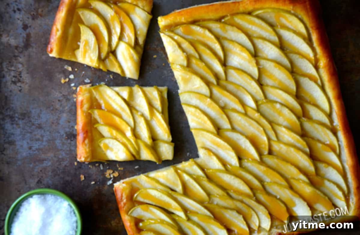 A delicious salted caramel apple tart with a piece sliced off.