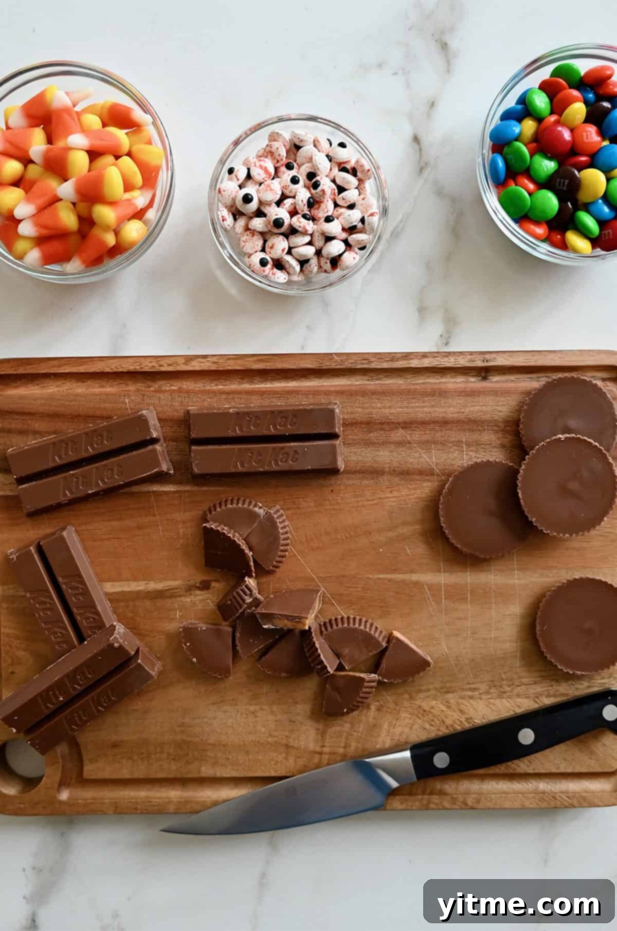 Chopping Reese's and KitKat bars into bite-sized pieces for chocolate bark.