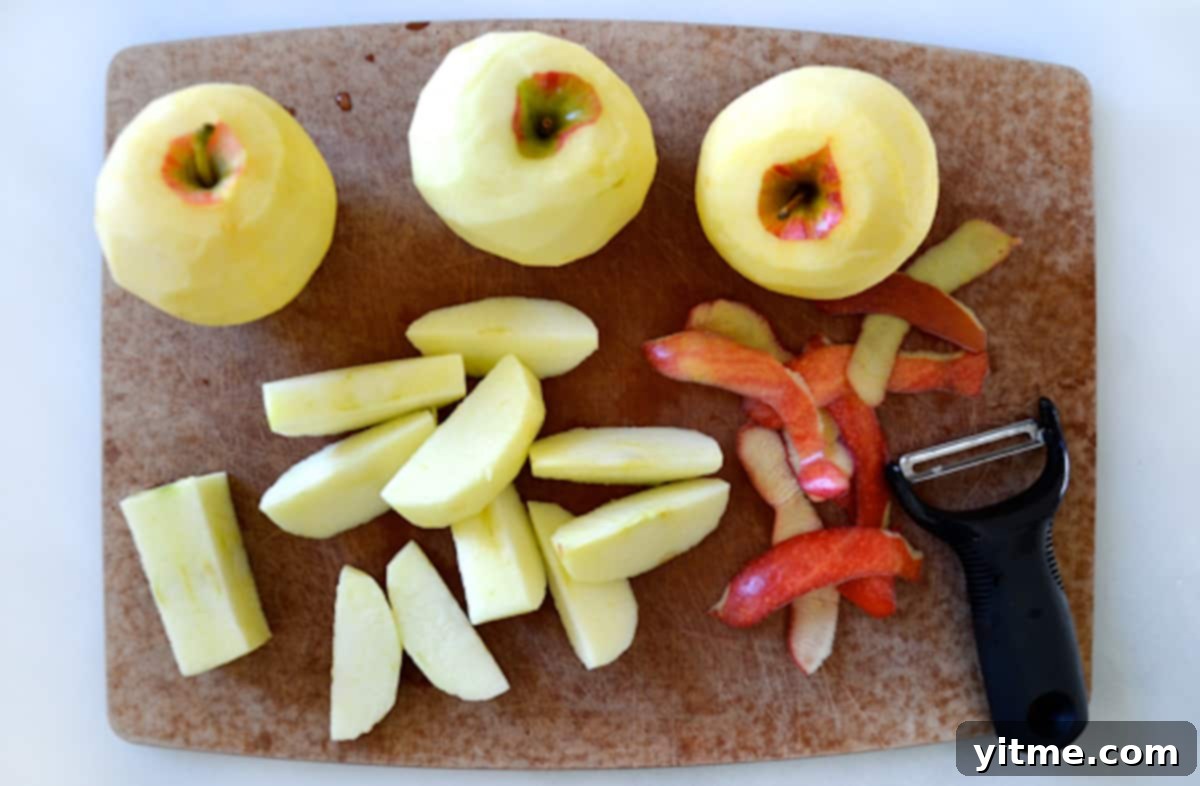 Peeled and sliced apples on a wooden cutting board